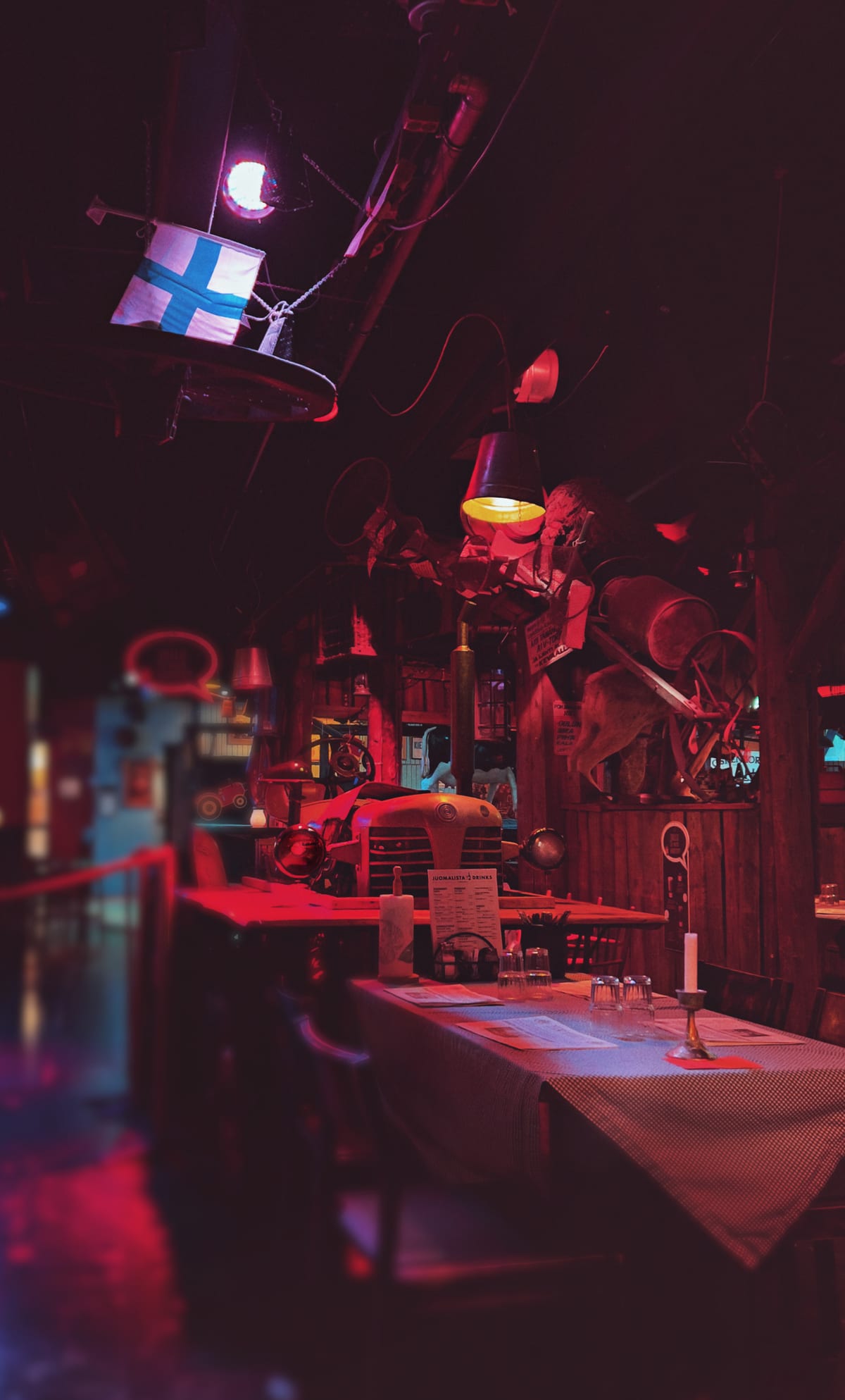 A tractor turned into a dining table in a room dimly lit by red light